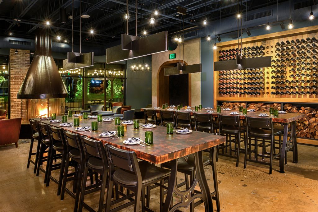 Basso on the Plaza with lights and tables and chairs and wine on the wall